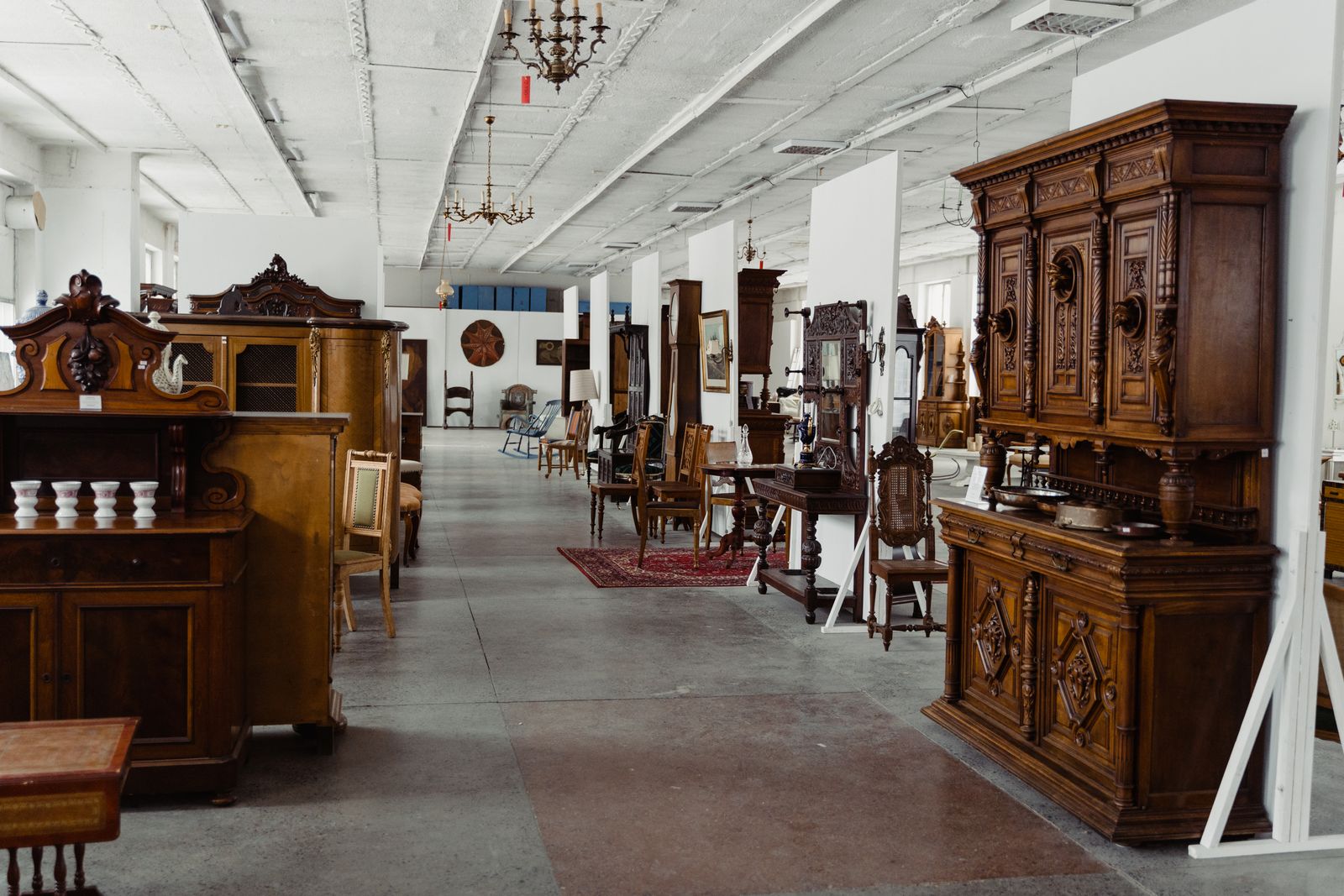 Antique and period furniture in a warehouse showroom, the kind of large items Proovia collects and delivers